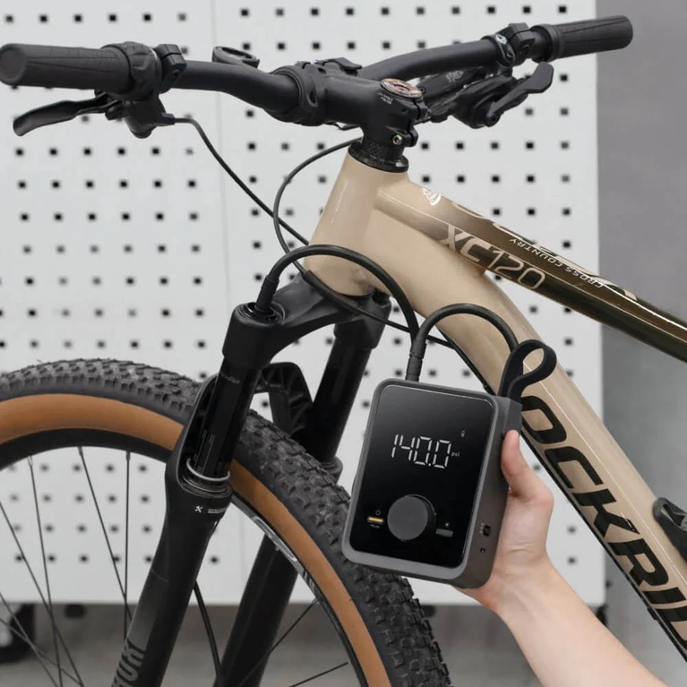 HOTO Air Pump Pro Portable Tire Inflator 120 PSI Bicycle with a power meter attached to the handlebar, against a white pegboard background.