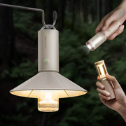hoto-portable-camplight-rechargeable-camping-light-ipx6 Two hands holding a hanging lamp and a flashlight against a dark background