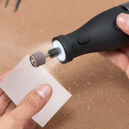 HOTO 12V Rotary Tool Kit Pro, Person using a black rotary tool with a sanding disc on a piece of paper against a brown background