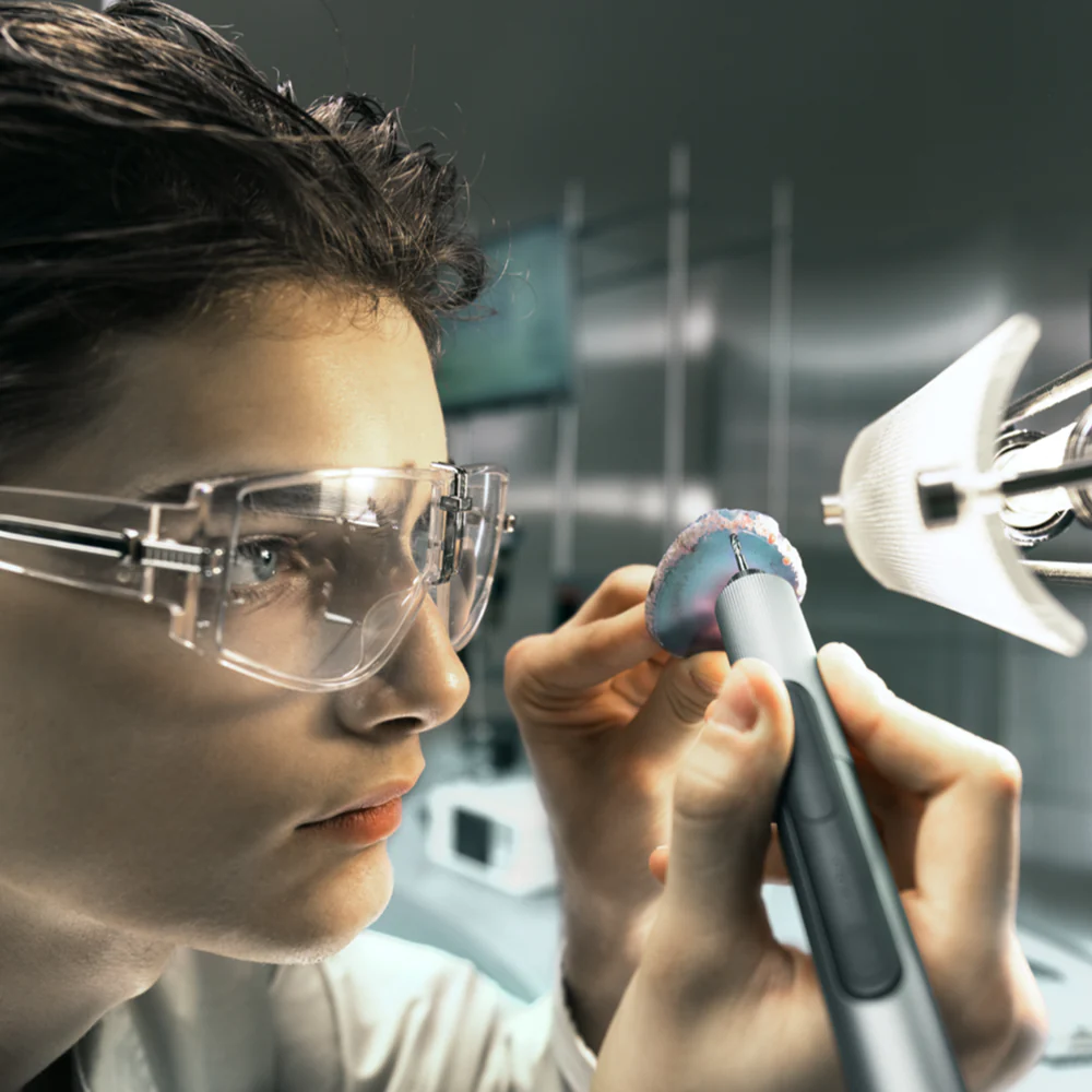 Person wearing safety goggles holding a tool in a futuristic setting