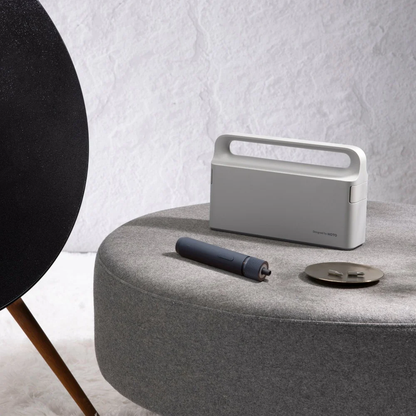 HOTO 3.6V Screwdriver Tool Set, Portable power station on a round gray table with a black speaker in the background