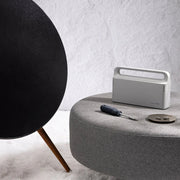 HOTO Household Tool Kit Multipurpose Set White portable speaker on a grey surface with a black spherical object and tools in the background.