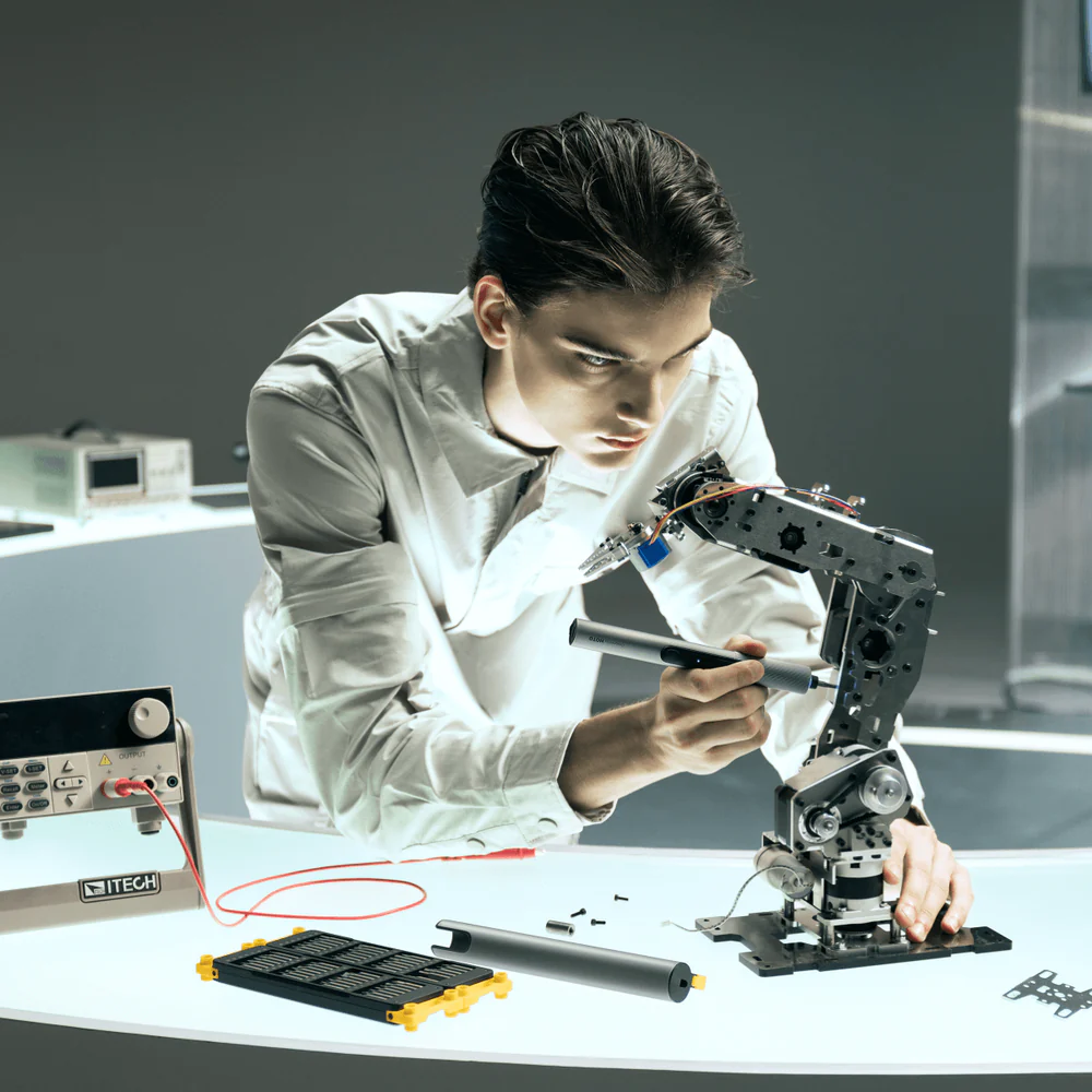 HOTO SNAPBLOQ S-A01 Electric Precision Screwdriver Set Person working on a mechanical device in a laboratory setting