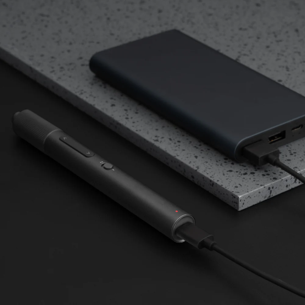Black power bank and pen on a dark surface