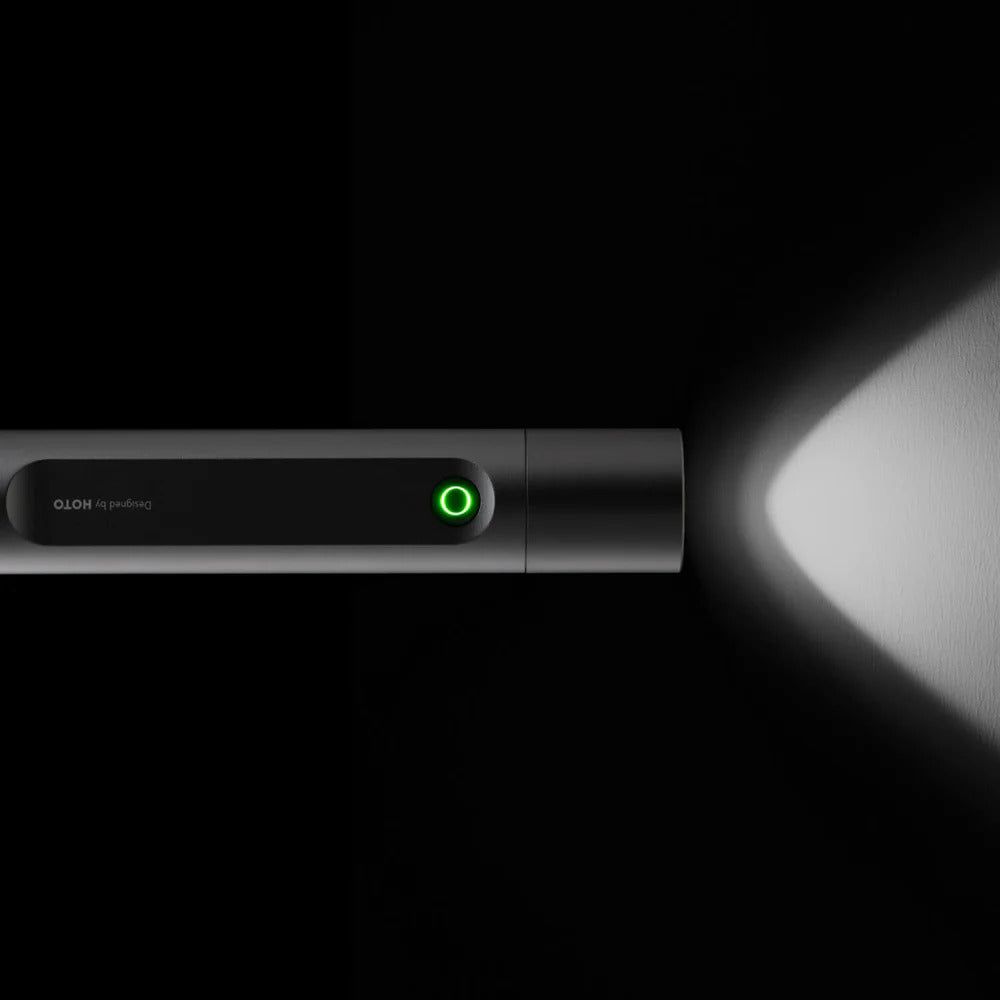 HOTO Flashlight Fit 280 Lumens Rechargeable Torch Black flashlight with a green light on, emitting light in a dark setting.