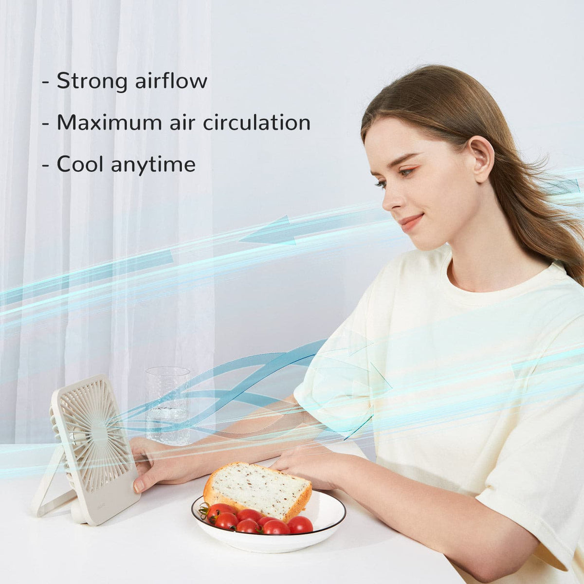 Jisulife Life1 Foldable Table Fan 2000mAh Portable USB-C Woman sitting at a table with a plate of food, using a small fan to cool herself.