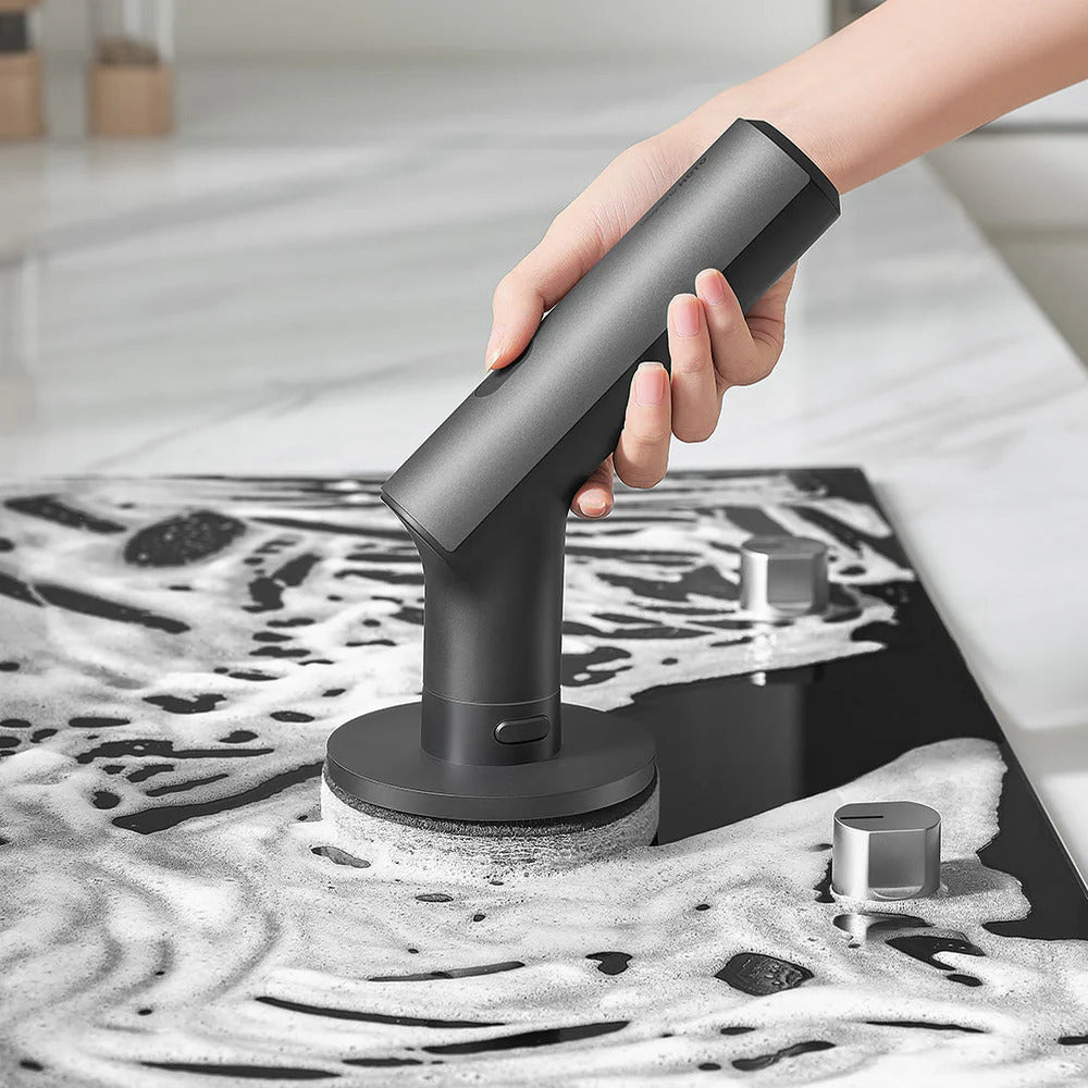 HOTO Cordless Spin Scrubber 6 Brush Head Set Person using a handheld cleaning tool on a soapy surface