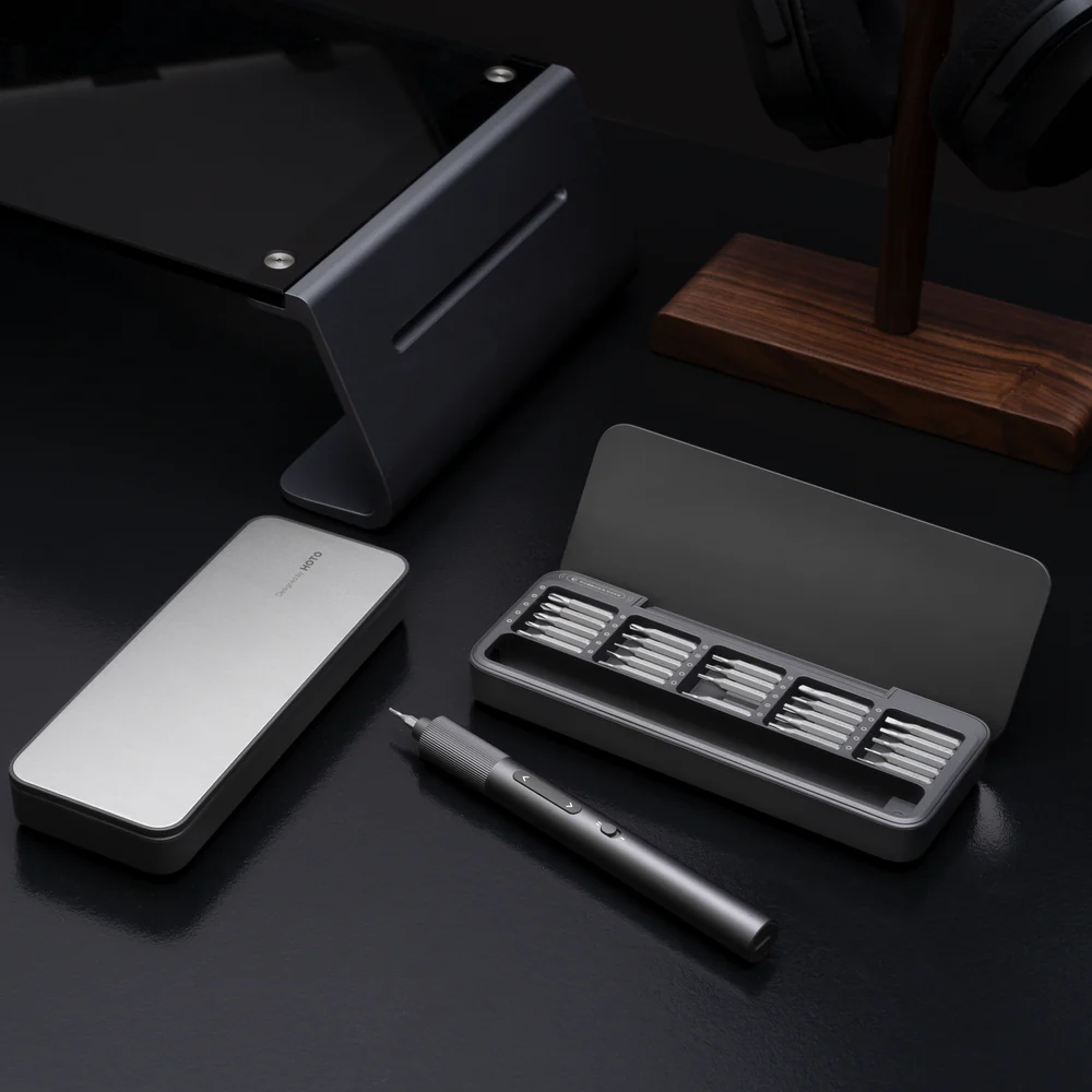 Set of tools including a pen, stand, and small box on a dark surface