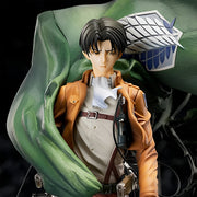 Figurine of a character from an anime or manga, wearing a brown jacket and white shirt, with a green cape and emblem.