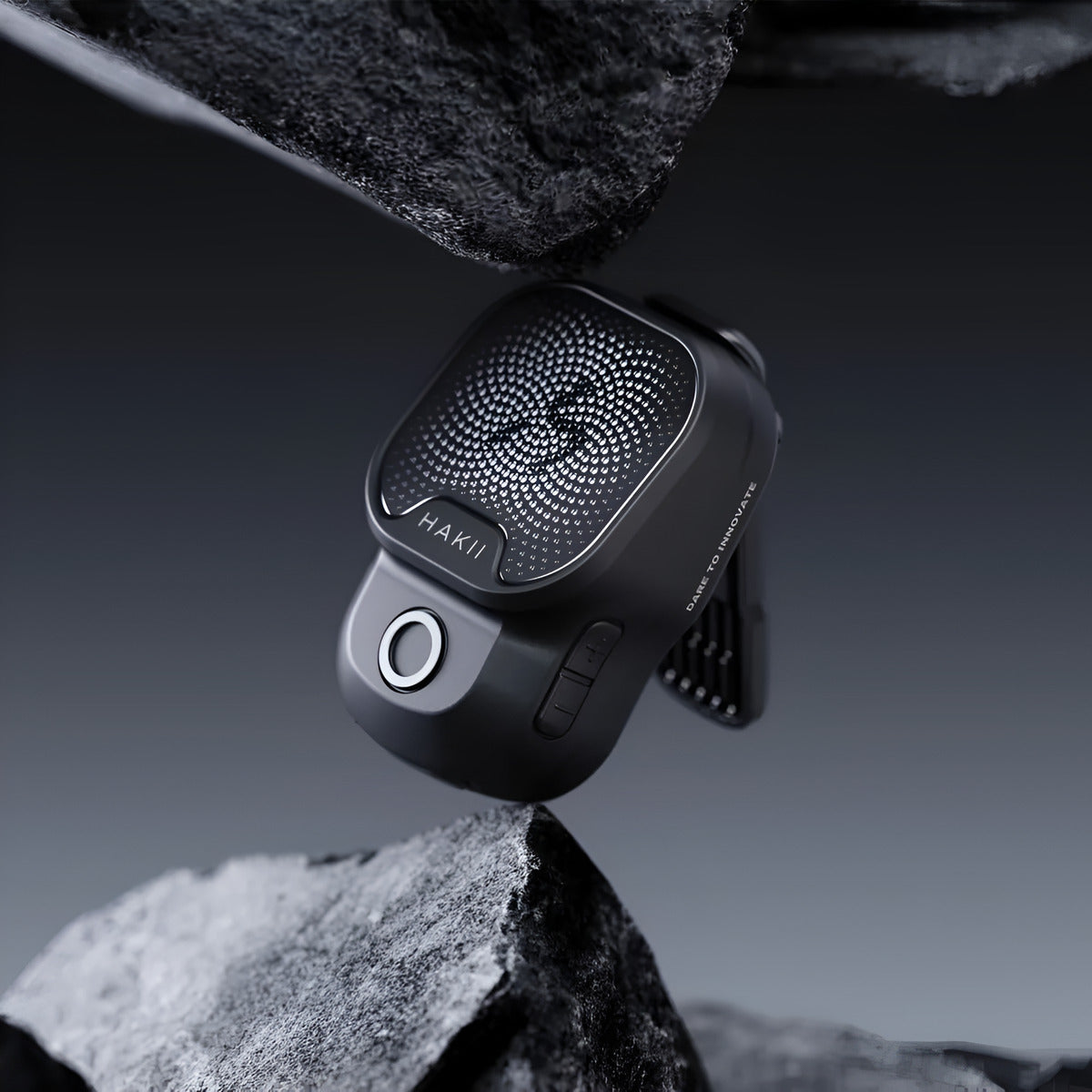 Black car air freshener on a rock with a dark background
