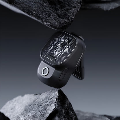 Black car air freshener on a rock with a dark background