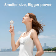 Jisulife Life5 Handheld Fan 2000mAh Portable Quiet USB-C Woman holding a white handheld device with a scenic background and text 'Smaller size, Bigger power'.
