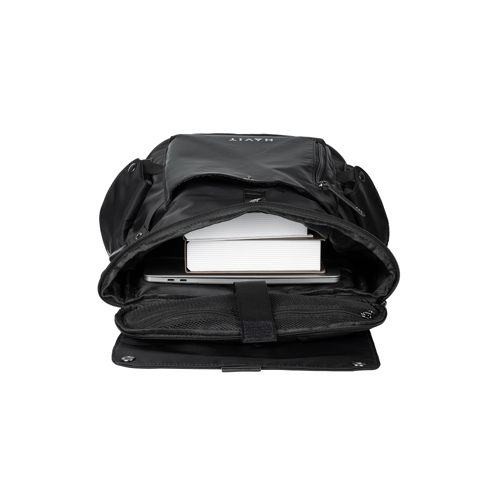 Black backpack with a laptop and books inside on a white background
