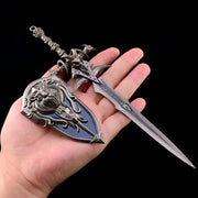 Decorative sword and shield held in a hand against a black background