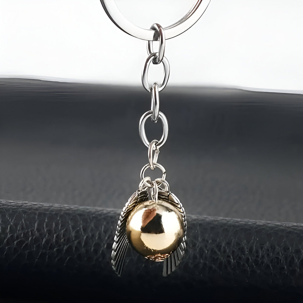 Keychain with gold ball and silver feather charm on a black surface / Harry Potter Golden Snitch Keyring