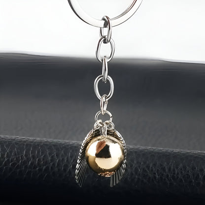 Keychain with gold ball and silver feather charm on a black surface / Harry Potter Golden Snitch Keyring