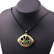 Gold pendant necklace with green gemstone on a black mannequin Marvels Doctor Strange - Eye of Agamotto Necklace